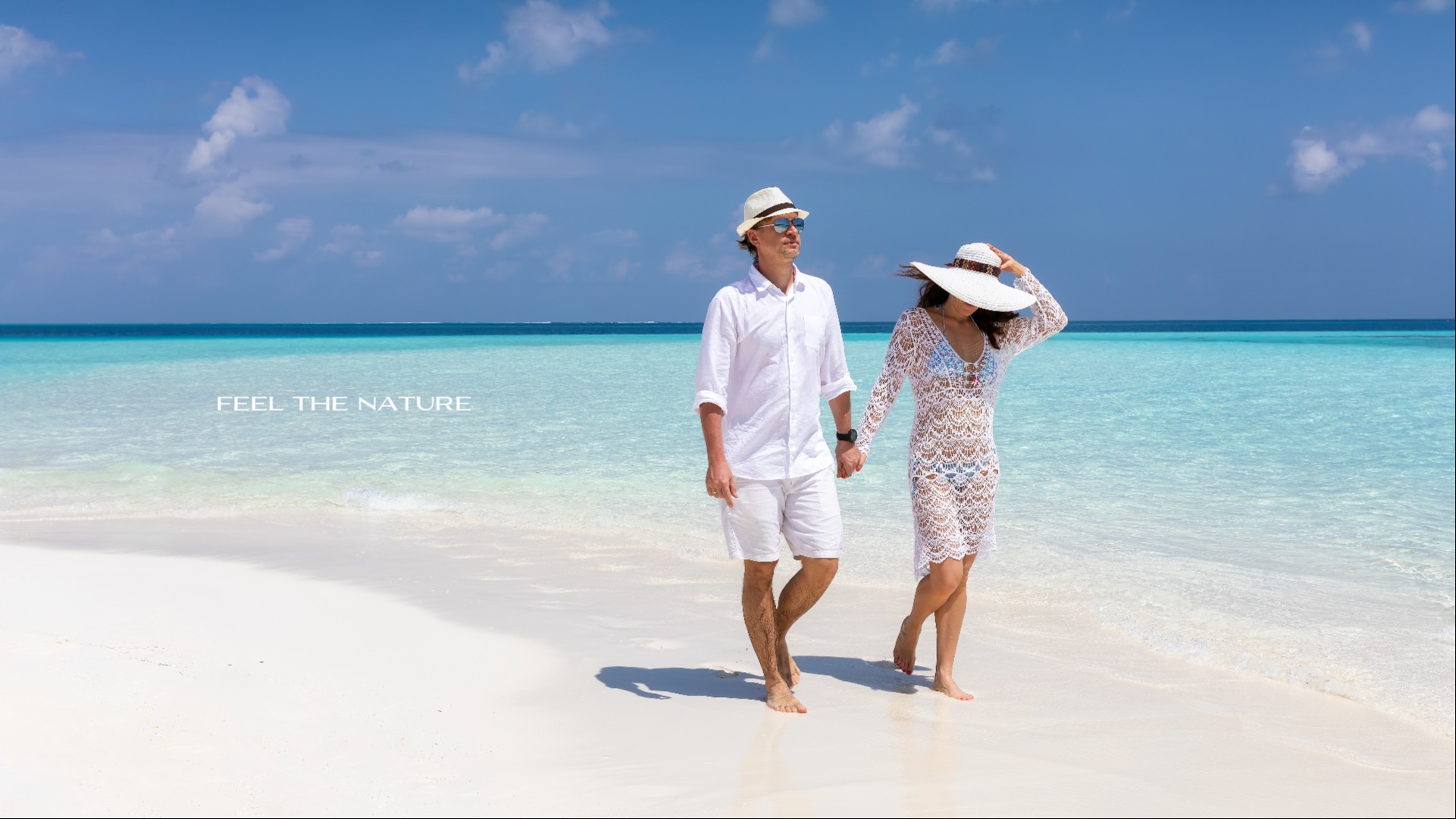 Couple walking along the beach with the title 'Feel the Nature'